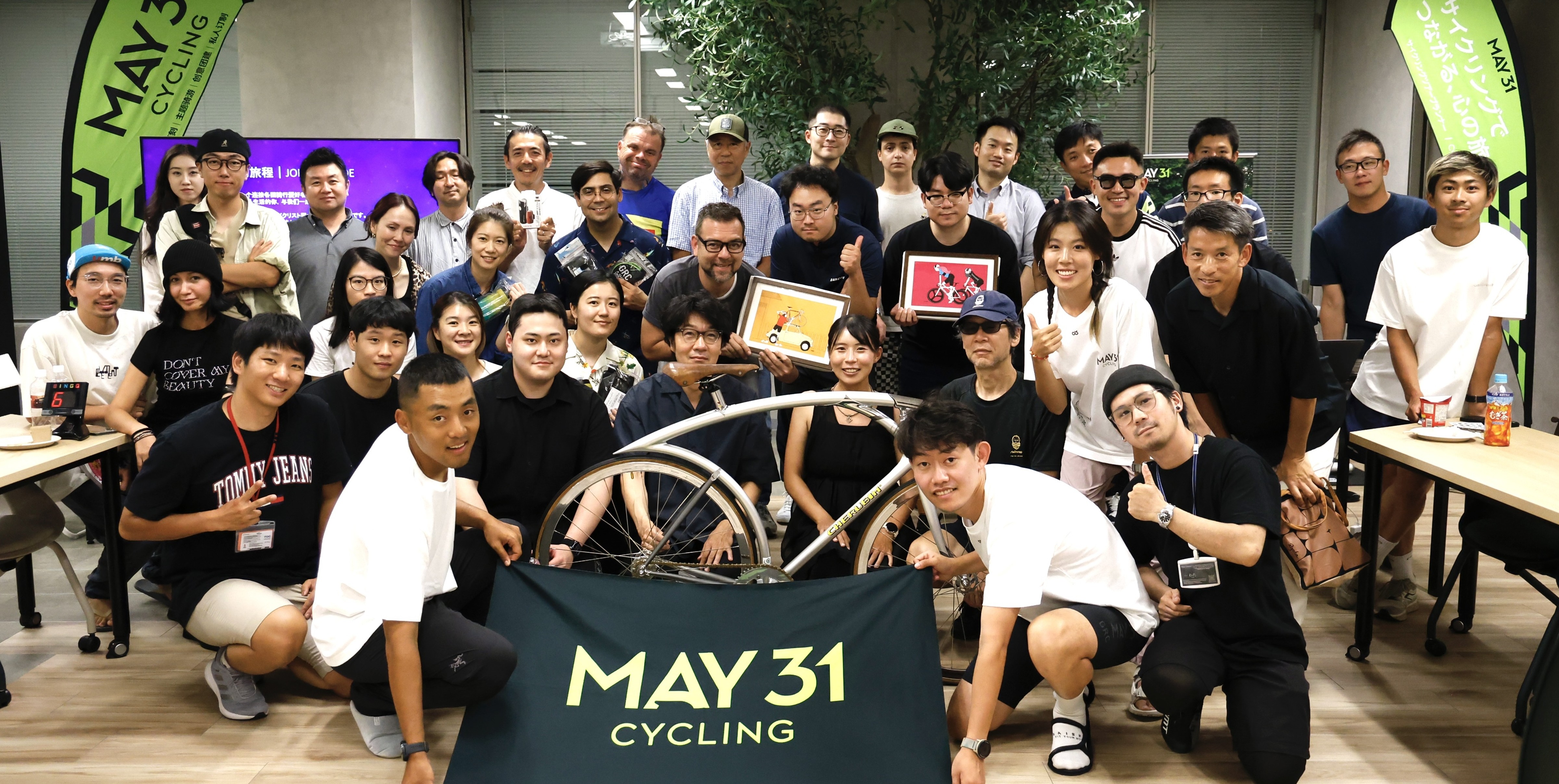 Cyclists with MAY31 banner on a coastal road